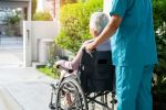 Caregiver help and care Asian senior or elderly old lady woman patient sitting on wheelchair to ramp in nursing hospital, healthy strong medical concept.